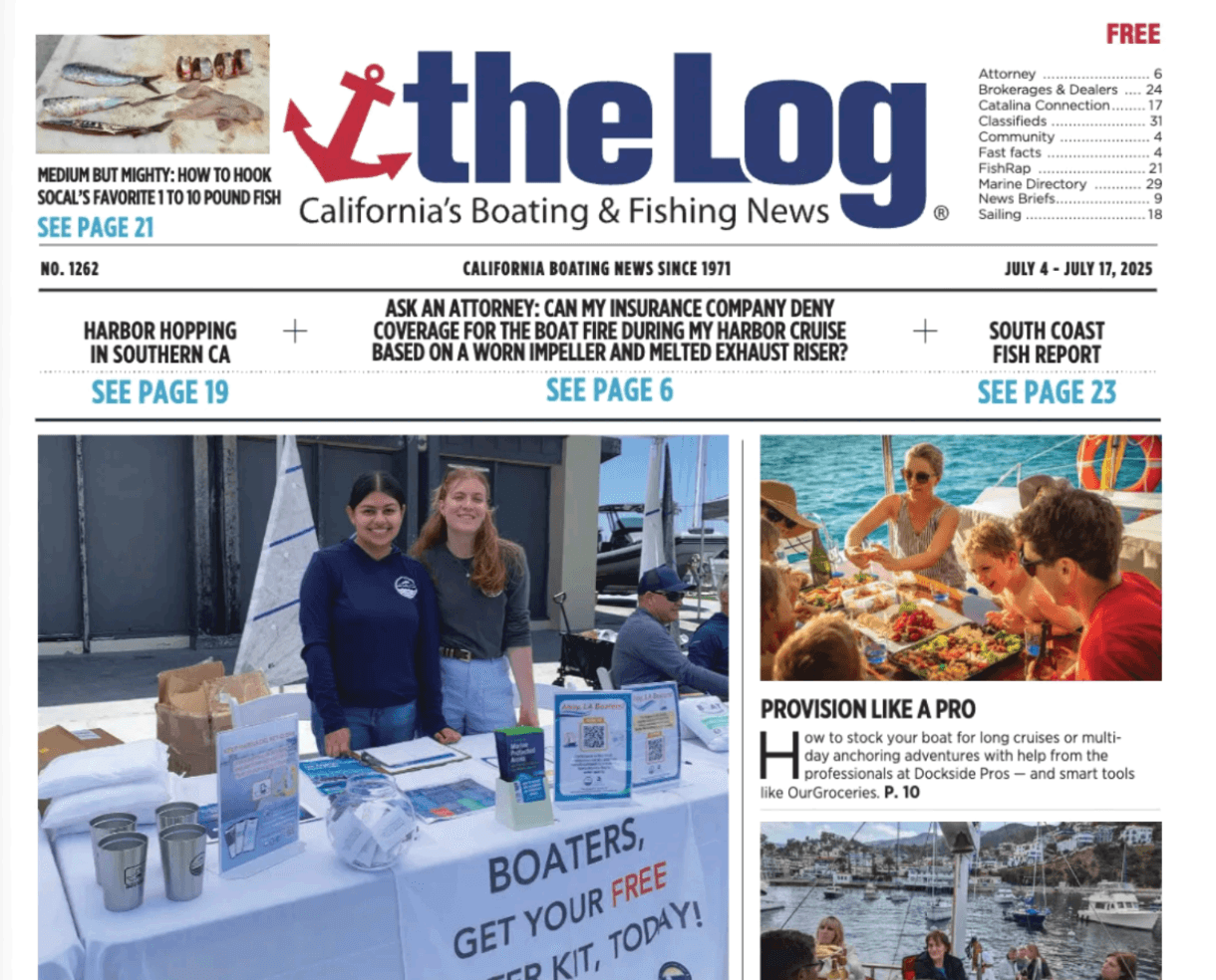 2 staffers behind a table with clean boating outreach materials on display
